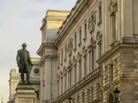 View of the Clive of India statue standing in front of the historic neoclassical architecture of the Foreign and Commonwealth Office building in London, England, United Kingdom.