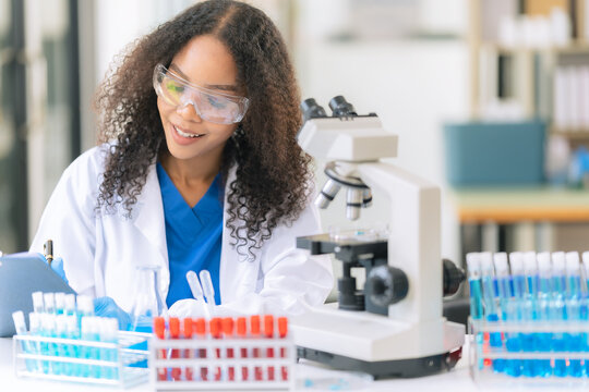 Diverse Female Scientists Conducting Research with Microscope and Chemical Flasks in Laboratory