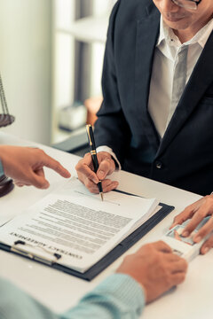 Lawyer and Client Signing Legal Contract Agreement Document in Law Office