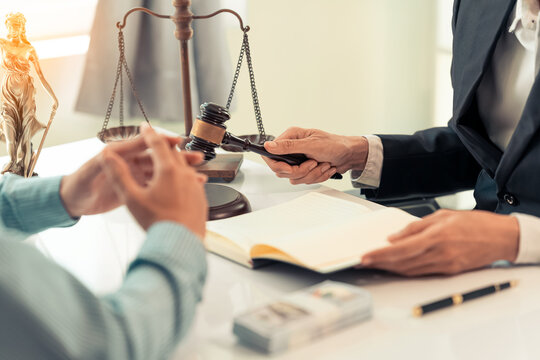 Lawyer and Client Signing Legal Contract Agreement Document in Law Office
