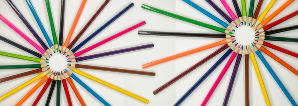 colored pencils are arranged in a circular pattern on a white surface