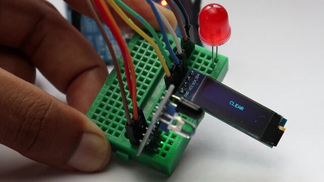 IR Infrared sensor on a breadboard circuit triggering an LED and displaying a message on OLED module when an obstacle is detected