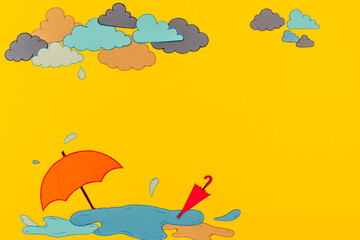 Fototapeta premium Bright yellow background features an orange umbrella on a puddle with clouds above