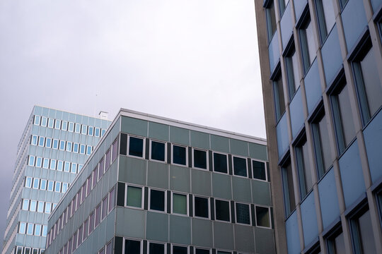 A sharp angle reveals modern office architecture in Oslo, Norway, where the sky meets windows and facade lines in a layered urban perspective.