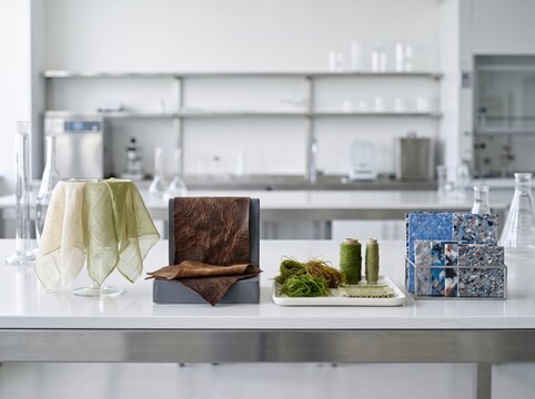 Sustainable fashion textile samples and eco material swatches on white lab table for fabric design and product development background