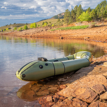 inflatable packraft (one-person light raft used for expedition or adventure racing) with a paddle on a lake shore in Colorado, on Horsetooth Reservoir