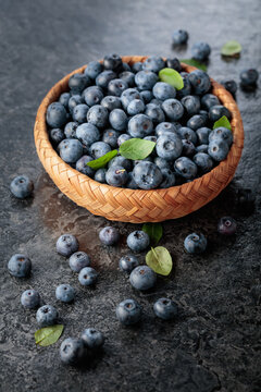 Blueberries with their leaves in wicker bowl.