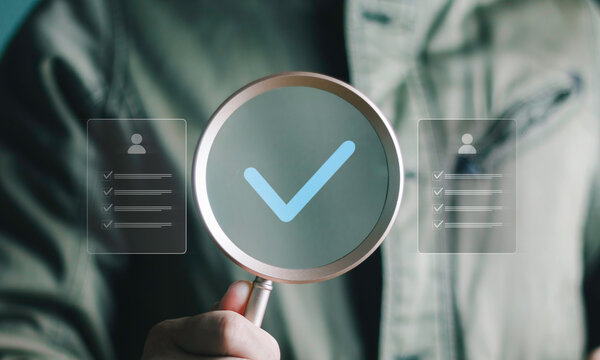 Professional using a magnifying glass with a digital checkmark and document interface, representing online audit, compliance, verification, approval, data review, accounting and secure processes.