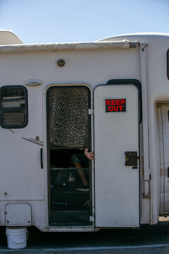Side entrance door and exterior wall of a white horse trailer with integrated living quarters, resembling a compact caravan or recreational vehicle (RV). The image highlights the practical combination