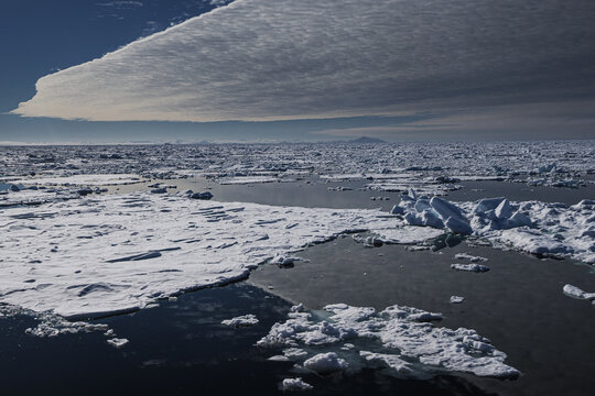 Melting sea ice and dramatic clouds in Arctic ocean landscape
