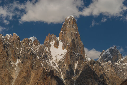 View of the Uli Biaho tower, a prominent granite spire in the Karakoram range, featuring snow-dusted peaks and rugged rock faces in Karakoram Mountaine Range, Gilgit Baltistan, Pakistan.