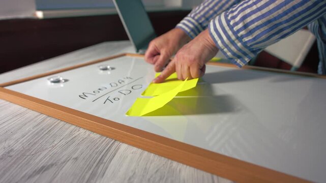 Woman with Monday morning schedule with sticky notes on whiteboard