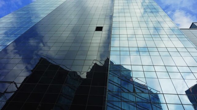 Modern glass skyscrapers and corporate office towers reflecting blue sky.