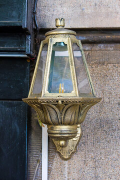Vintage old glass lantern hanging outside on street building facade