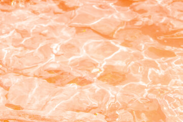 Fototapeta premium Full frame close up view of bright orange water ripples with golden sunlight reflections and caustics pattern background surface concept of pool ocean liquid photo
