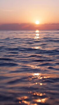 Beautiful sunset over the calm ocean waves with golden light reflecting on the water surface.