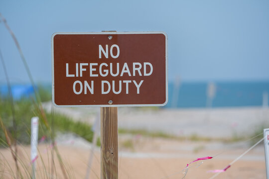 Sign Posted at Beach Warning That No Lifeguard is on Duty