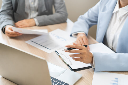 Business meeting, asian group brainstorm analysis on graph data of cost plan. financial consult planning investor asses and present to client, client and advisor review investment strategy in office.