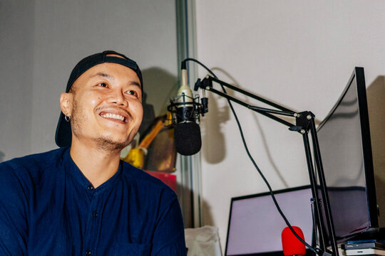 Podcast host at home studio With Computer Equipment and a Microphone
