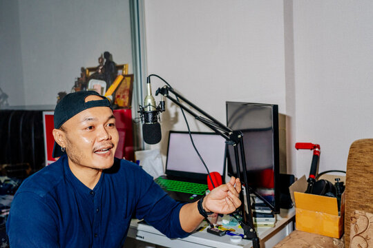 Podcast host at home studio With Computer Equipment and a Microphone