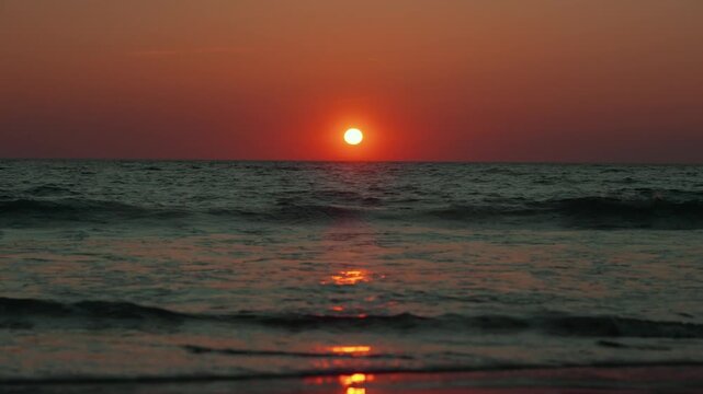 Orange beach sunset reflecting on ocean waves, sea landscape summer video