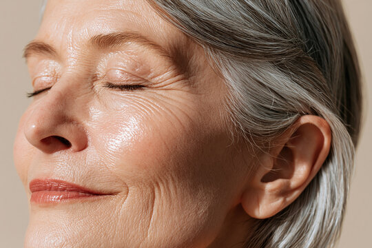 Elegant elderly woman skin close up mature woman portrait senior woman face cheekbone detail silver hair closed eyes smile lines natural skin texture beauty macro skincare focus