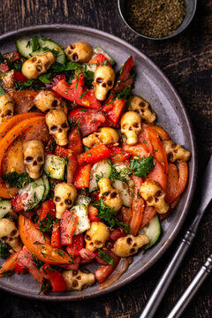 Halloween salad with vegetables and cheese in shape of skull