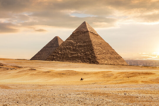Mysterious pyramids in Giza desert under sunset sky in Egypt