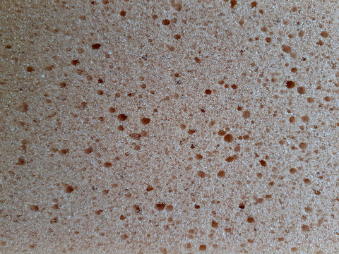 Peach foam sponge background. Soft foaming part of a body wash sponge. Pink absorbent part with holes.