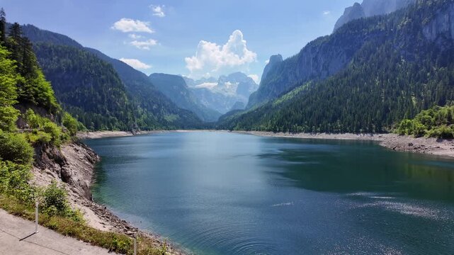 Aerial View Gosau Alpine Lake Beneath Dachstein Mountains

Drone footage reveals tranquil mountain waters framed by forests and dramatic peaks, Gosau, Austria, 11 August 2026.

