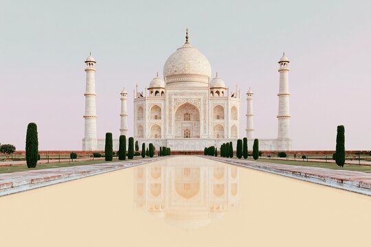 White marble mausoleum reflected in a smooth water pool at dusk with a delicate blush sky for Indian tourism and travel brand advertising