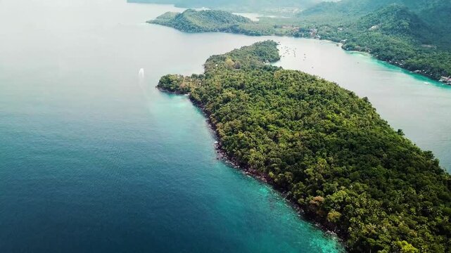 Aerial view of a lush tropical island surrounded by turquoise ocean water