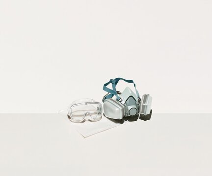 Professional elastomeric respirator with glossy safety goggles on a sterile pouch, featuring matte filters and silicone textures for medical preparedness with copy space
