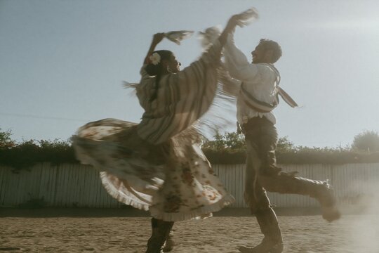 Chilean huaso couple dancing cueca in a sunlit arena with a flowing poncho and spinning floral dress for folk culture and heritage content