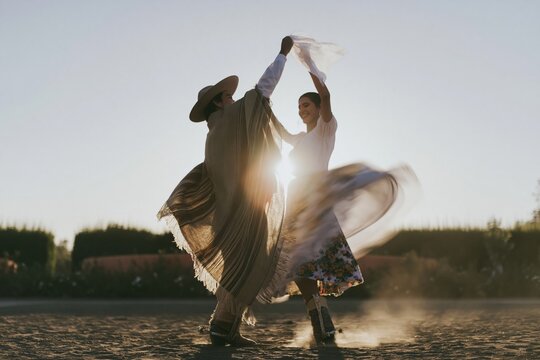 A young couple in traditional Chilean huaso attire performs a spirited cueca dance on dusty ground for national celebration and cultural content