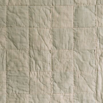 Weathered sage and khaki cotton patchwork quilt background with hand-stitched seams and tactile puckered texture for family lifestyle and nursery design