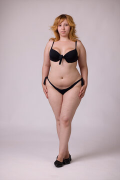Confident curvy woman posing in black bikini