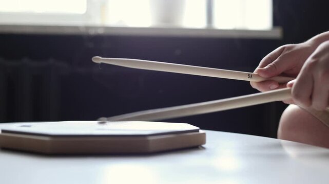 Close-up of hands practicing drum beats on a practice pad