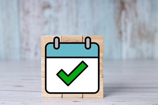 "Task completed" concept, calendar checklist icon on wooden cubes.