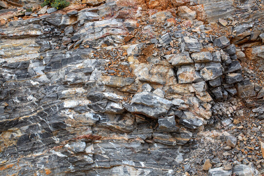 Detailed Texture of Fractured Grey Sedimentary Rock Face with Mineral Veins