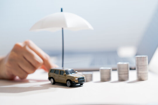 Car insurance concept. Vehicle under umbrella with rising coins represents financial protection and risk planning, coverage, safety, savings, finance, security