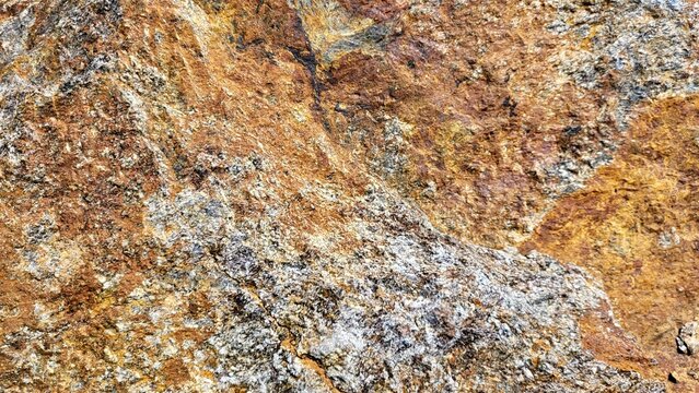 Close-up of weathered rock in distinctive rust brown and gray tones, revealing unique natural structures, textures and mineral patterns.
