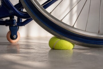 Wheelchair wheel with tennis ball on a smooth floor