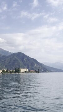 Scenic view of Lake Como and mountains with boats and plants in Italy