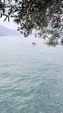 Boat cruising across Lake Como with mountains in the background, Italy