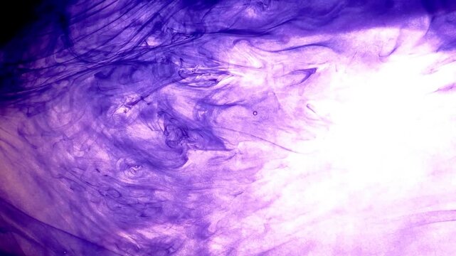 Abstract purple and violet ink dissolving and spreading naturally in water.