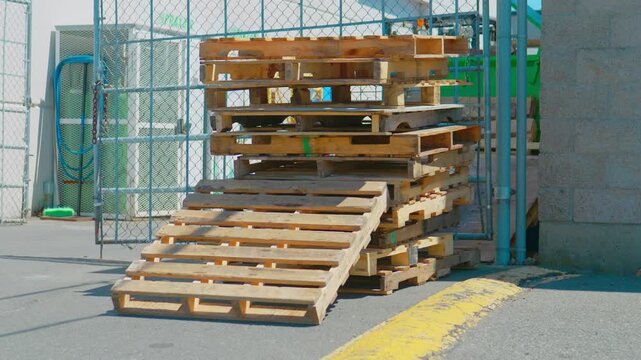 Wooden pallets stacked by industrial chain link security fence