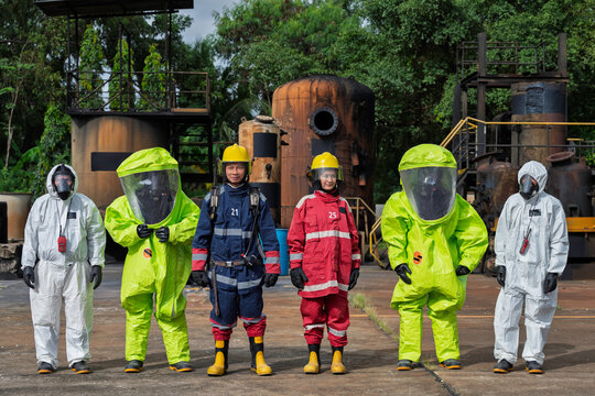Hazmat and rescue team stands ready at an industrial facility during confined space emergency training. Concept of hazardous materials response, workplace safety, rescue, and disaster preparedness.