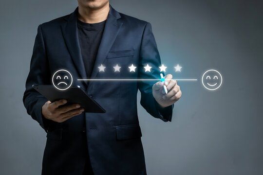 Businessman using a tablet to select a five star customer satisfaction rating on a digital scale