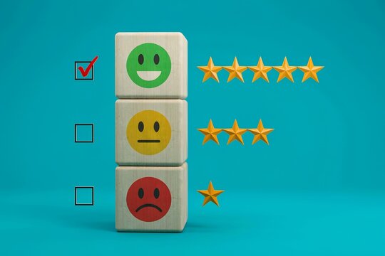 Customer feedback concept with wooden blocks showing smiley faces and star ratings on teal blue